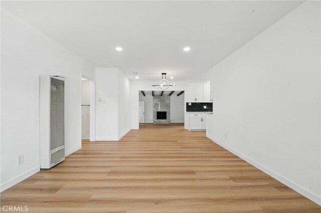 611 S Thorson Ave, Compton, CA 90221 - unfurnished living room featuring a heating unit, baseboards, a high end fireplace, light wood-type flooring, and recessed lighting