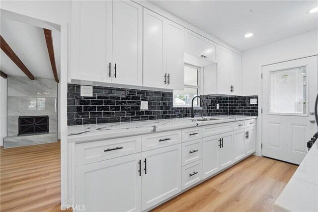 611 S Thorson Ave, Compton, CA 90221 - kitchen featuring a sink, light wood-style flooring, white cabinets, decorative backsplash, and recessed lighting