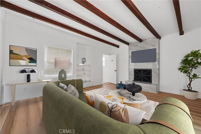 611 S Thorson Ave, Compton, CA 90221 - living room with beam ceiling, wood finished floors, a fireplace, baseboards, and built in shelves