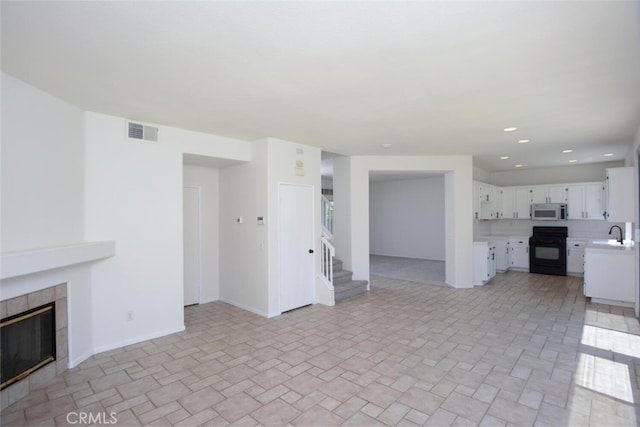 27292 Eagles Nest Dr, Corona, CA 92883 - unfurnished living room featuring a sink, a tile fireplace, stairway, baseboards, and recessed lighting