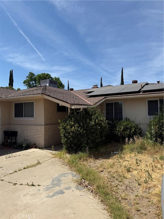 4115 E Dayton Ave, Fresno, CA 93726 - view of front facade featuring brick siding, solar panels, and stucco siding