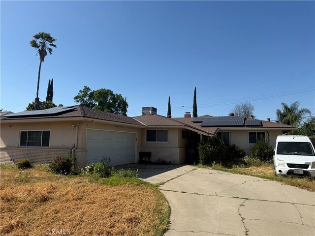 4115 E Dayton Ave, Fresno, CA 93726 - ranch-style home featuring brick siding, solar panels, driveway, and a garage
