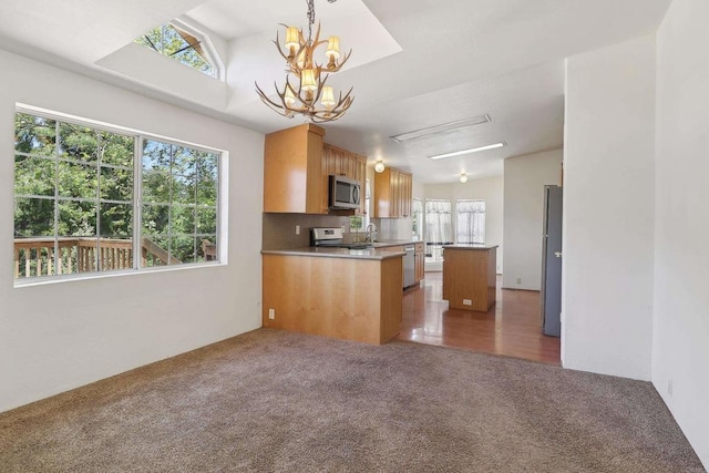 34387 Wolahi Rd, Julian, CA 92036 - kitchen with appliances with stainless steel finishes, light colored carpet, a chandelier, a sink, and pendant lighting