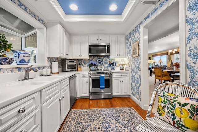 4007 Calle Sonora Oeste Unit 1A, Laguna Woods, CA 92637 - kitchen featuring appliances with stainless steel finishes, dark wood-style flooring, a sink, white cabinets, and light countertops