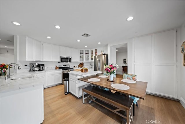 1528 Hendrix Pl, Chula Vista, CA 91911 - kitchen with stainless steel appliances, white cabinets, a sink, glass insert cabinets, and recessed lighting