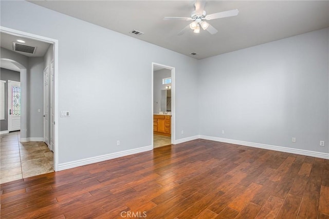 967 Hidden Oaks, Beaumont, CA 92223 - spare room featuring arched walkways, a ceiling fan, dark wood-style flooring, and baseboards