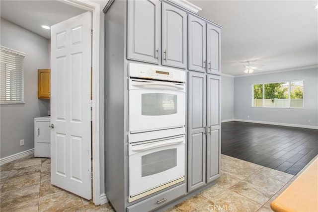 967 Hidden Oaks, Beaumont, CA 92223 - kitchen with white double oven, gray cabinets, washer / clothes dryer, baseboards, and a ceiling fan