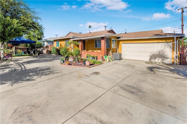 10636 Wolfe Ave, Riverside, CA 92505 - ranch-style home with driveway, a garage, brick siding, and central air condition unit