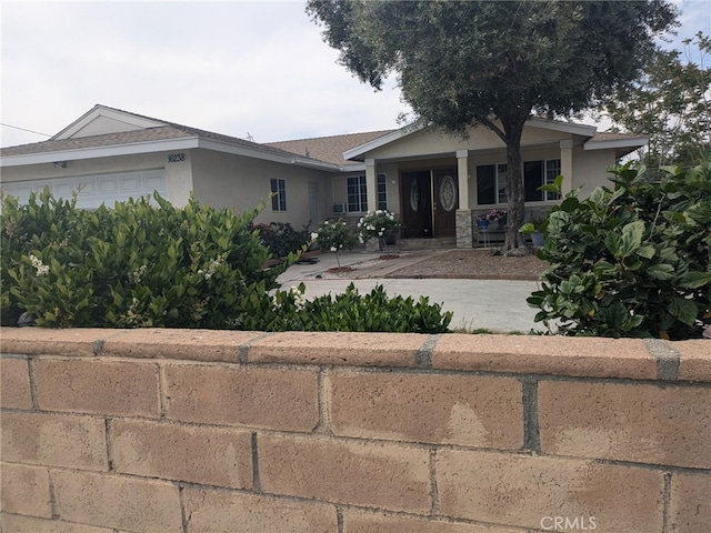 16238 Merrill Ave, Fontana, CA 92335 - ranch-style house featuring stucco siding, a garage, and covered porch