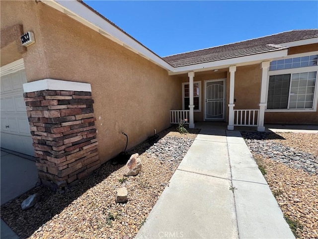13633 Bentwood St, Hesperia, CA 92344 - doorway to property with stucco siding, a porch, and a garage