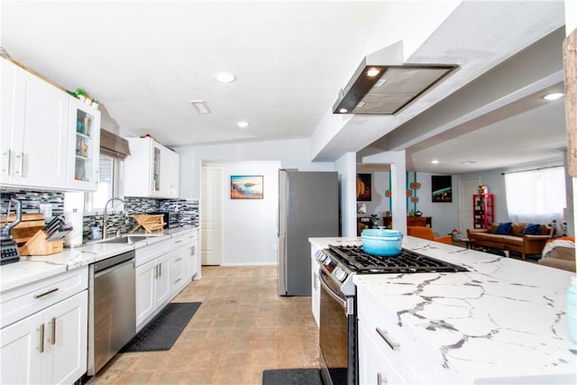 5536 Cahuilla Ave Unit 29, Palms, CA 92277 - kitchen featuring appliances with stainless steel finishes, a sink, glass insert cabinets, light stone countertops, and white cabinetry
