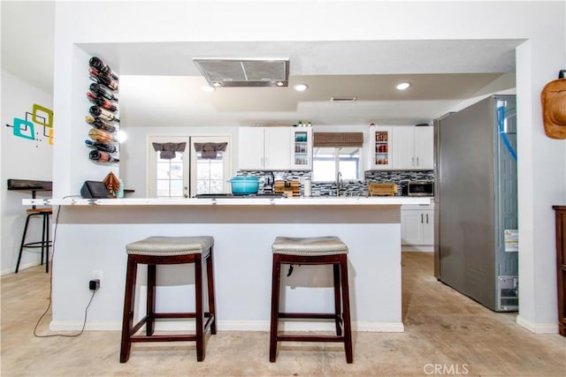5536 Cahuilla Ave Unit 29, Palms, CA 92277 - kitchen featuring stainless steel appliances, a breakfast bar area, white cabinets, and recessed lighting