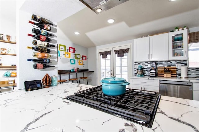 5536 Cahuilla Ave Unit 29, Palms, CA 92277 - kitchen featuring stainless steel dishwasher, stovetop, white cabinetry, glass insert cabinets, and recessed lighting