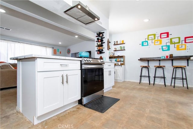 5536 Cahuilla Ave Unit 29, Palms, CA 92277 - kitchen featuring electric stove, white cabinets, concrete flooring, a breakfast bar area, and recessed lighting