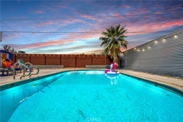 5536 Cahuilla Ave Unit 29, Palms, CA 92277 - pool at dusk with a fenced backyard and a patio area