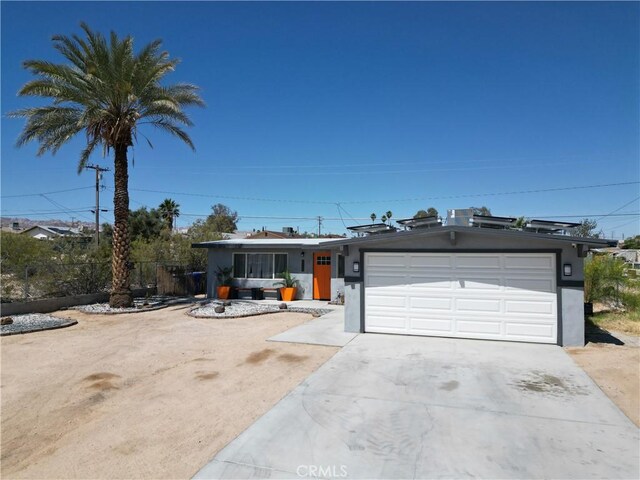 5536 Cahuilla Ave Unit 29, Palms, CA 92277 - view of front facade featuring driveway, an attached garage, and stucco siding