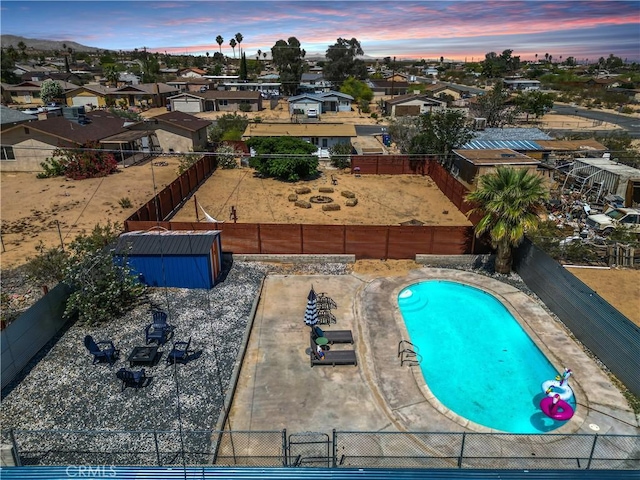 5536 Cahuilla Ave Unit 29, Palms, CA 92277 - view of swimming pool featuring a fenced backyard, a residential view, and a storage unit