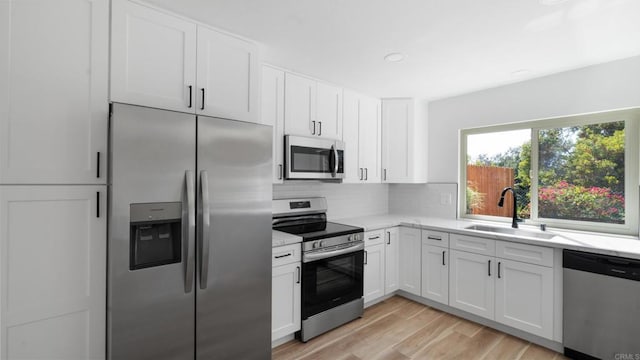 1524 Bridgeview Dr, San Diego, CA 92105 - kitchen with stainless steel appliances, a sink, tasteful backsplash, white cabinets, and light stone counters