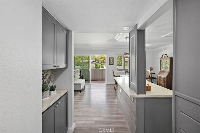 676 Via Alhambra Unit C, Laguna Woods, CA 92637 - bar area featuring wood finished floors, crown molding, and a textured ceiling
