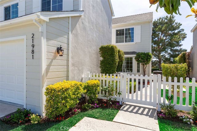 21981 Birchwood, Mission Viejo, CA 92692 - view of exterior entry featuring a garage, a gate, and stucco siding
