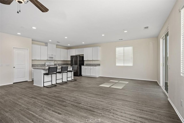 508 Bristolwood Rd, Hemet, CA 92543 - kitchen with freestanding refrigerator, white microwave, open floor plan, white cabinets, and recessed lighting