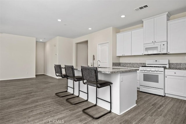508 Bristolwood Rd, Hemet, CA 92543 - kitchen featuring white appliances, a kitchen island with sink, dark wood-type flooring, white cabinets, and recessed lighting