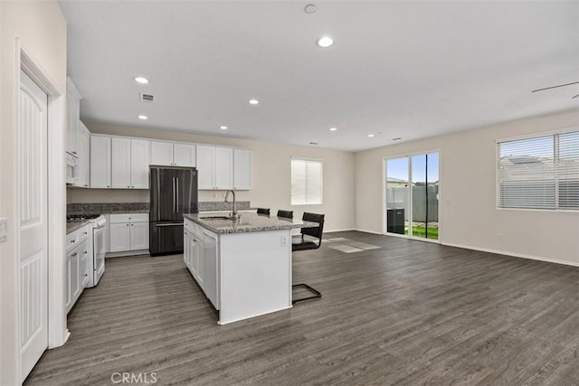 508 Bristolwood Rd, Hemet, CA 92543 - kitchen with white appliances, an island with sink, dark wood-style floors, white cabinetry, and open floor plan