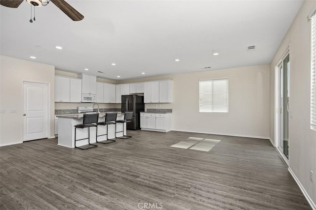 508 Bristolwood Rd, Hemet, CA 92543 - kitchen with white microwave, freestanding refrigerator, open floor plan, white cabinets, and recessed lighting