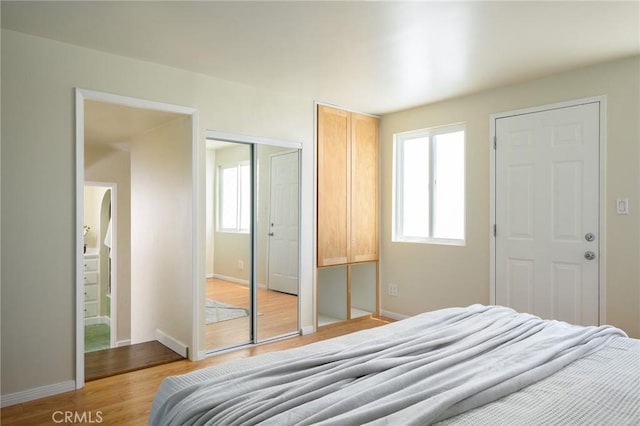 26 Covina Ave, Long Beach, CA 90803 - bedroom with multiple windows, light wood-style floors, and baseboards