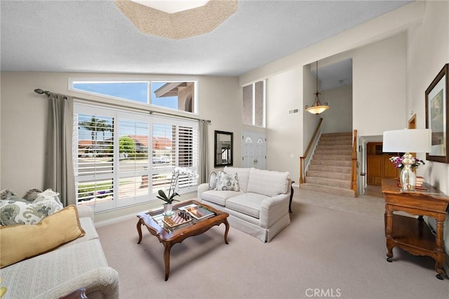 20161 Glacier Cir, Huntington Beach, CA 92646 - living area featuring carpet floors, stairway, a towering ceiling, and baseboards