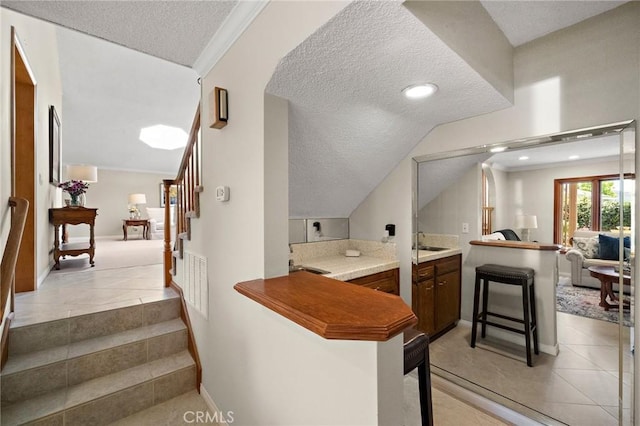 20161 Glacier Cir, Huntington Beach, CA 92646 - kitchen featuring a sink, a textured ceiling, a peninsula, vaulted ceiling, and open floor plan