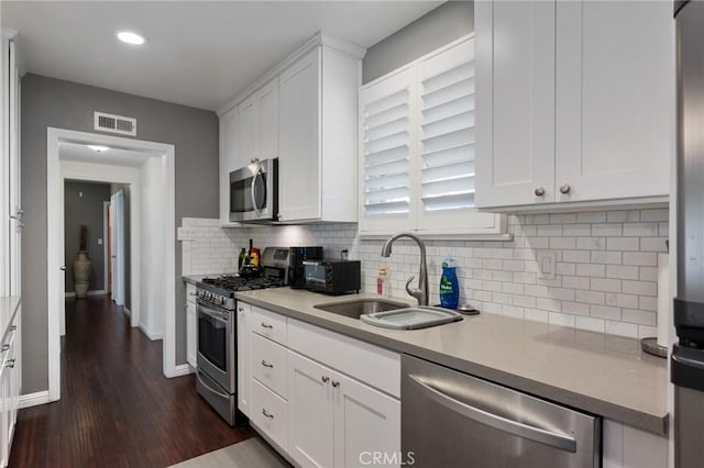 14017 S Wilkie Ave, Gardena, CA 90249 - kitchen with appliances with stainless steel finishes, a sink, white cabinets, light countertops, and dark wood-style flooring