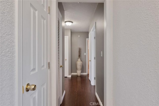 14017 S Wilkie Ave, Gardena, CA 90249 - hallway featuring a textured ceiling, dark wood-style floors, baseboards, and a textured wall