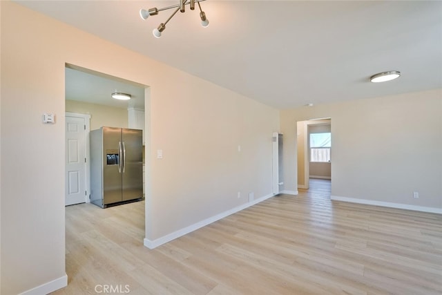1221 Westminster Ave, East Palo Alto, CA 94303 - empty room featuring light wood-style floors, baseboards, and a chandelier