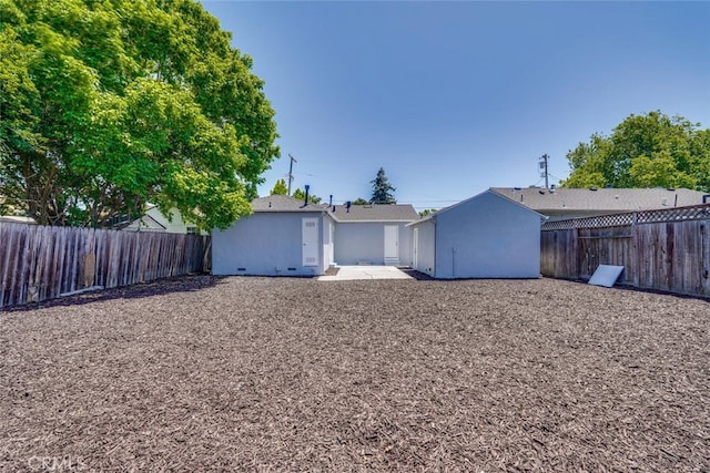 1221 Westminster Ave, East Palo Alto, CA 94303 - back of property with a fenced backyard, stucco siding, and a patio