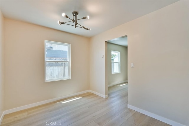 1221 Westminster Ave, East Palo Alto, CA 94303 - empty room with a chandelier, light wood finished floors, and baseboards