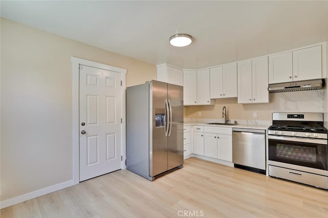 1221 Westminster Ave, East Palo Alto, CA 94303 - kitchen with appliances with stainless steel finishes, under cabinet range hood, a sink, light wood-type flooring, and white cabinets