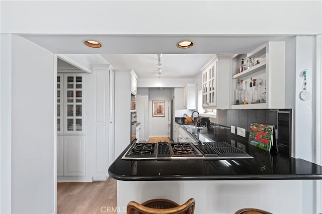 1800 Highland Ave, Manhattan Beach, CA 90266 - kitchen with open shelves, white cabinets, dark countertops, light wood finished floors, and glass insert cabinets