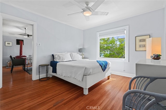 1800 Highland Ave, Manhattan Beach, CA 90266 - bedroom with crown molding, a wood stove, wood finished floors, baseboards, and a ceiling fan
