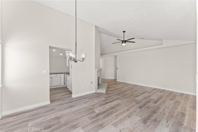 1318 Washington Ave, San Jacinto, CA 92583 - unfurnished living room featuring ceiling fan, a chandelier, light wood-style floors, high vaulted ceiling, and baseboards