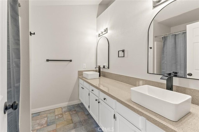 1318 Washington Ave, San Jacinto, CA 92583 - bathroom featuring double vanity, stone finish flooring, baseboards, and curtained shower