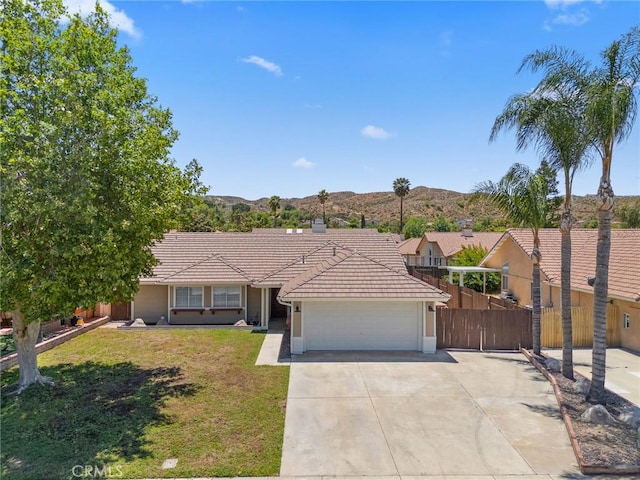 1318 Washington Ave, San Jacinto, CA 92583 - ranch-style house with a tiled roof, an attached garage, driveway, a mountain view, and stucco siding