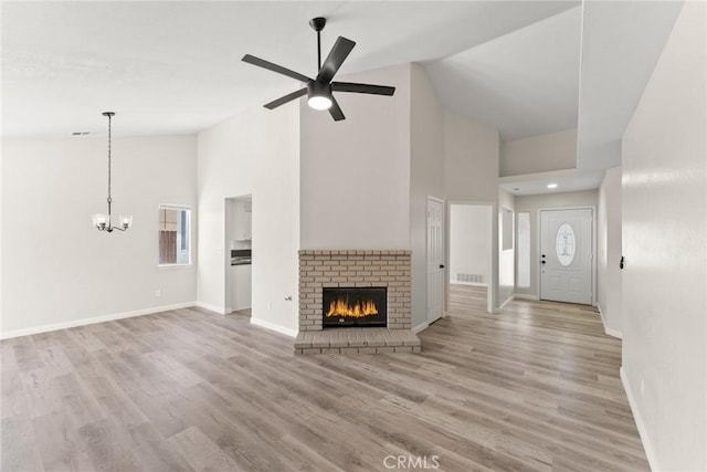 1318 Washington Ave, San Jacinto, CA 92583 - unfurnished living room featuring high vaulted ceiling, a chandelier, baseboards, a brick fireplace, and a ceiling fan