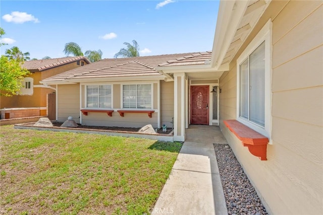 1318 Washington Ave, San Jacinto, CA 92583 - view of exterior entry featuring a yard and a tile roof