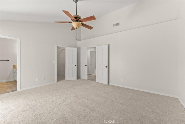 1318 Washington Ave, San Jacinto, CA 92583 - unfurnished bedroom featuring carpet flooring, baseboards, high vaulted ceiling, connected bathroom, and a walk in closet