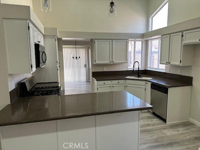 1318 Washington Ave, San Jacinto, CA 92583 - kitchen with stainless steel dishwasher, a sink, gas range, black microwave, and a peninsula