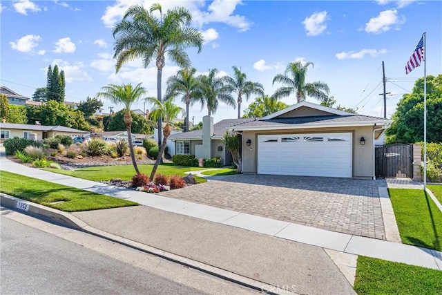 1050 Shelburne Ln, Habra, CA 90631 - single story home with decorative driveway, a front yard, an attached garage, and stucco siding