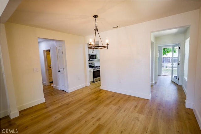 417 S Murdock Ave, Willows, CA 95988 - unfurnished dining area featuring a chandelier, light wood-style floors, and baseboards