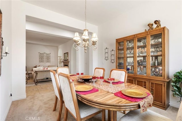 11538 Stoney Brook Ct, Beaumont, CA 92223 - dining space with light carpet, a chandelier, arched walkways, and baseboards