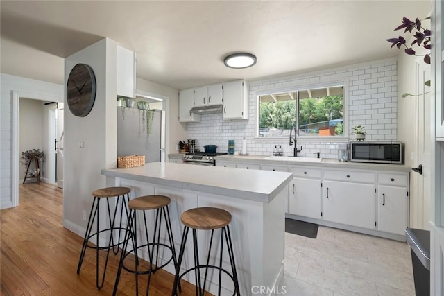 1215 Sylvia Ct, San Luis Obispo, CA 93401 - kitchen featuring a sink, appliances with stainless steel finishes, decorative backsplash, and a peninsula